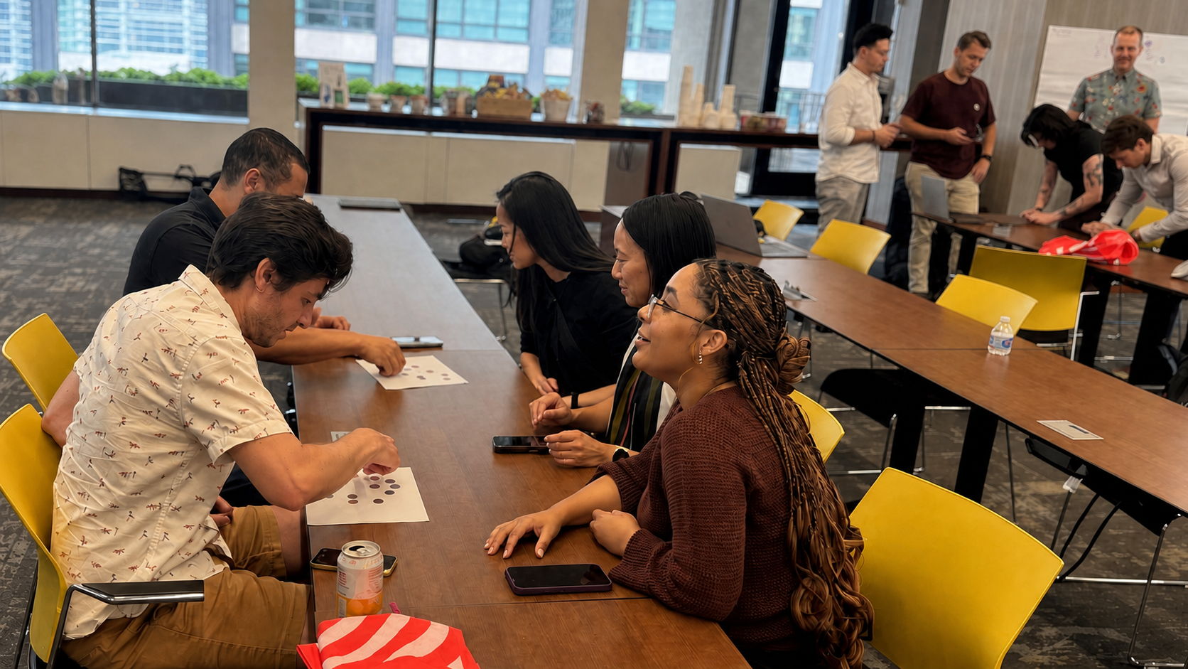 Workshop participants collaborating around tables with colorful notes and activity materials